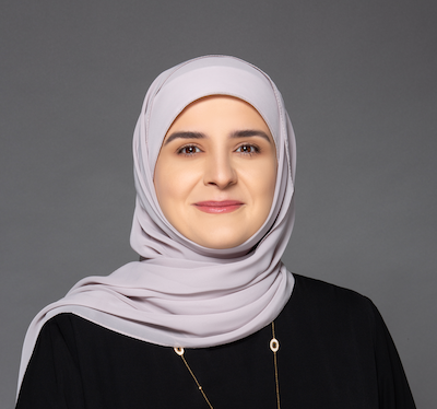Zainab wearing a purple scarf, and a necklace