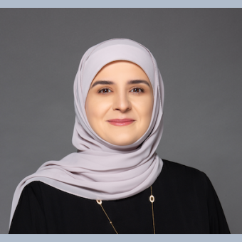 Zainab wearing a purple scarf, and a necklace 